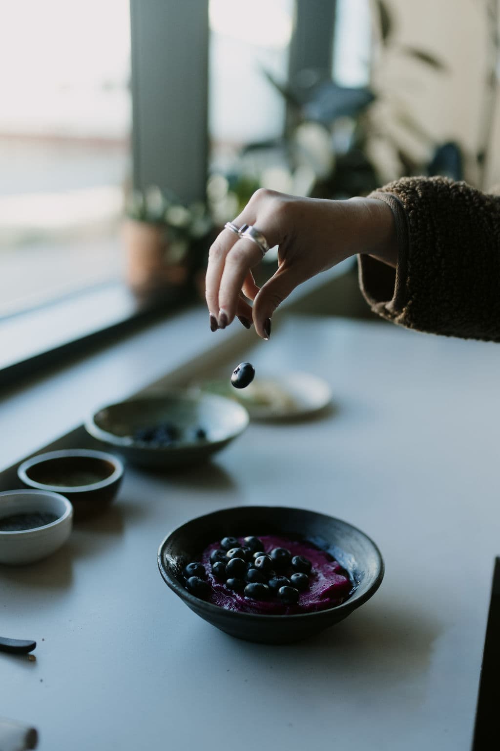 Hand garnishing a fresh açaí bowl